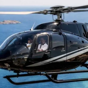 Luxury helicopter flying over the turquoise Aegean Sea between Mykonos and Paros on a scenic island transfer.