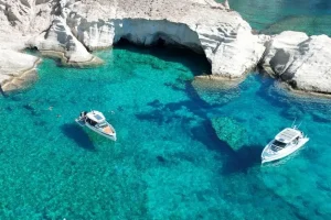 Luxury yachts anchored in crystal-clear Antiparos waters during a private day cruise departing from Paros, Greece